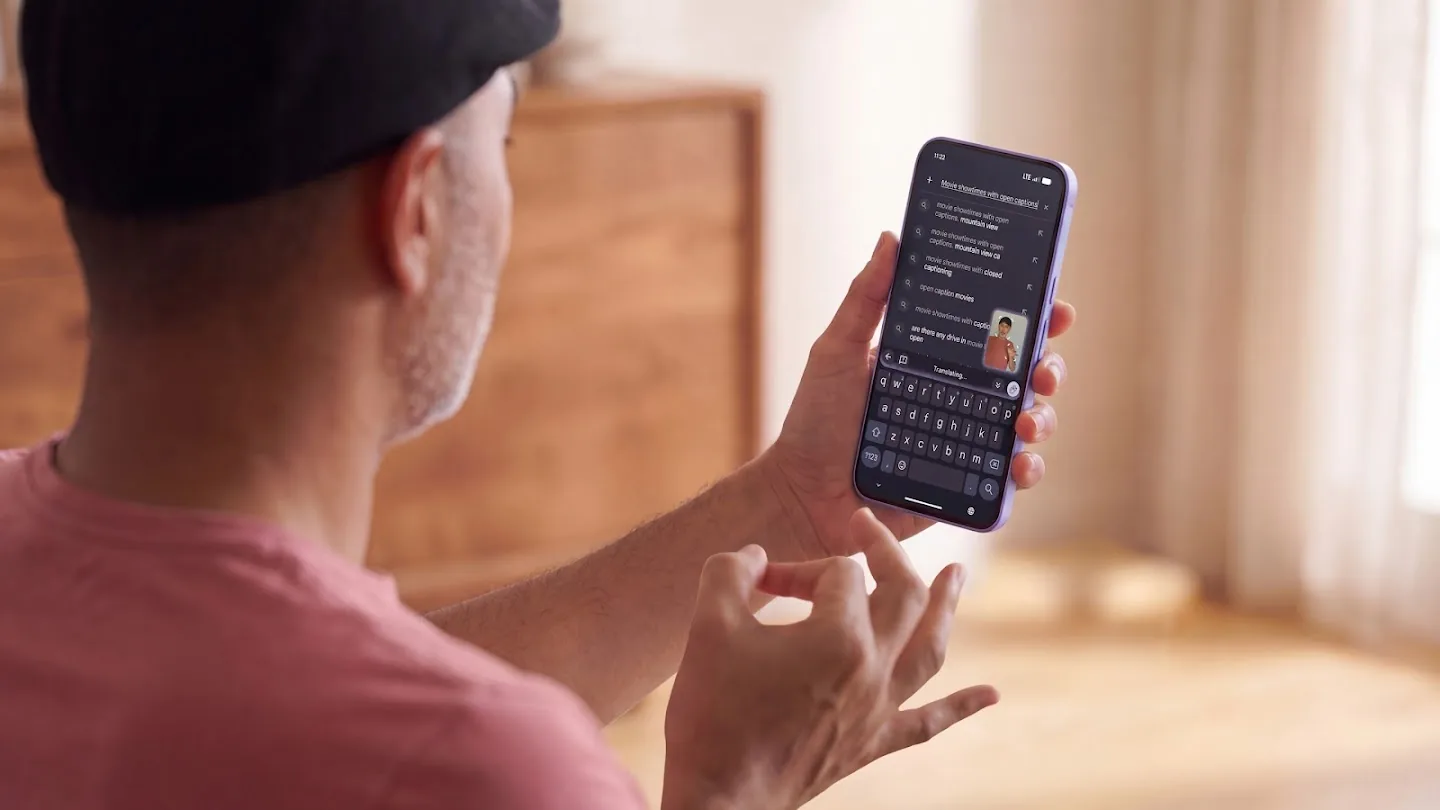 Una persona hace señas con una mano mientras sostiene un smartphone, en una demostración del dictado por señas de Gboard.