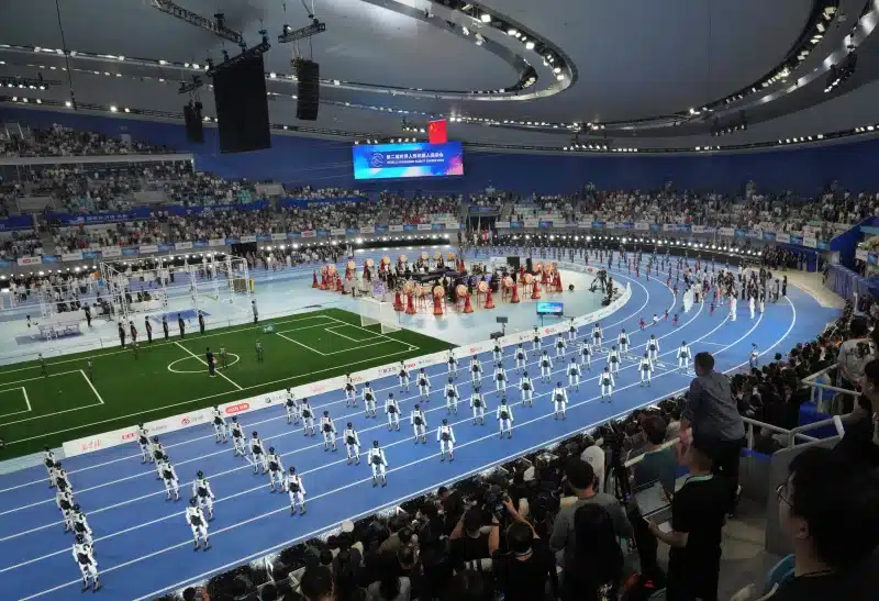 Robots compiten en los 100 metros durante la ceremonia de apertura de los World Humanoid Robot Games en Pekín, el sábado 22 de agosto de 2026. (AP Photo/Achmad Ibrahim)