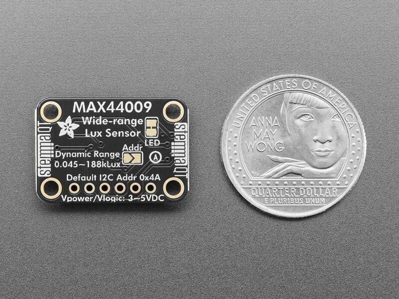 Cara trasera del MAX44009 con la dirección I2C 0x4A y el rango impreso, junto a una moneda para escala