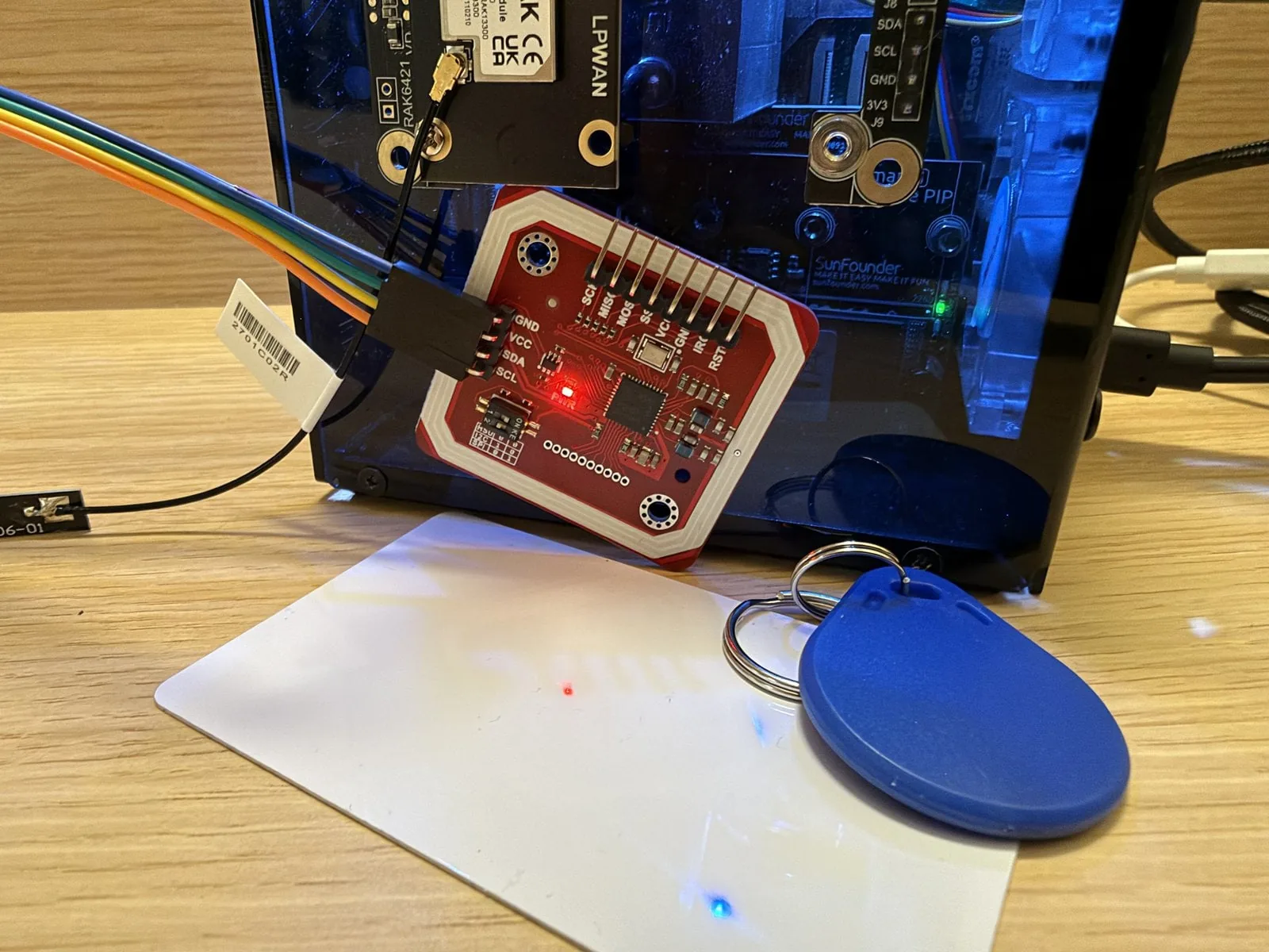 PN532 conectado al conector GPIO de una Raspberry Pi 5 que además tiene un HAT de radio dentro de su gabinete