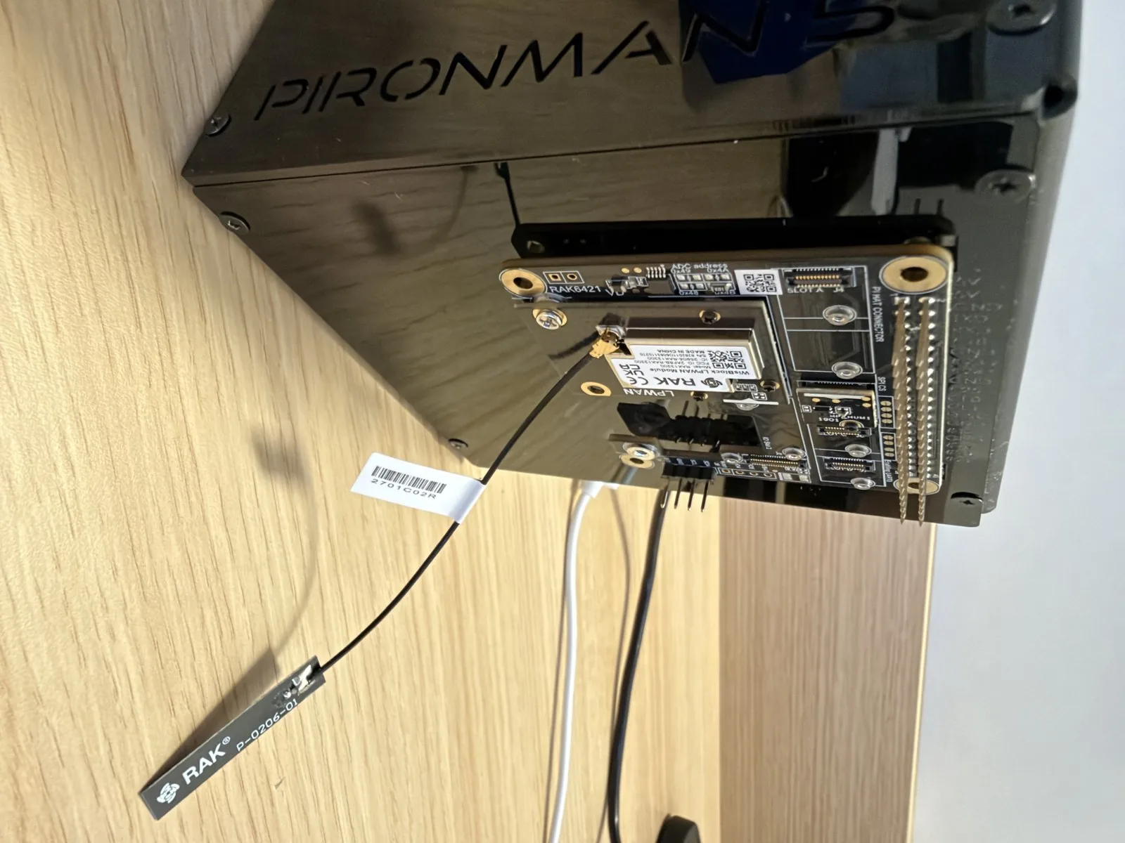 HAT RAK6421 con módulo de radio y antena montado por fuera sobre el header GPIO de un gabinete Pironman