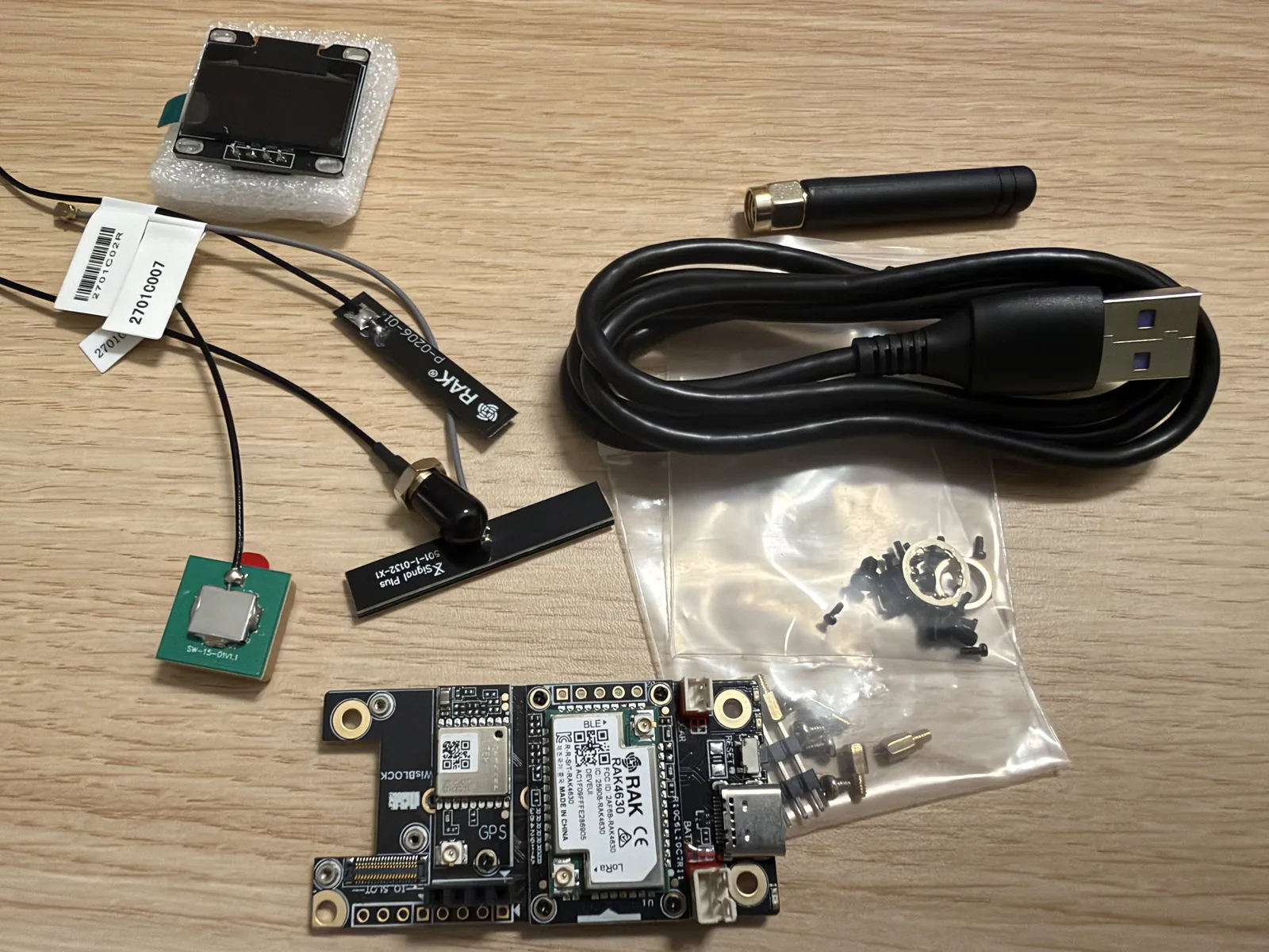 Contenido del WisMesh RAK4631 Starter Kit: placa base, pantalla OLED, antenas, cable USB y tornillos