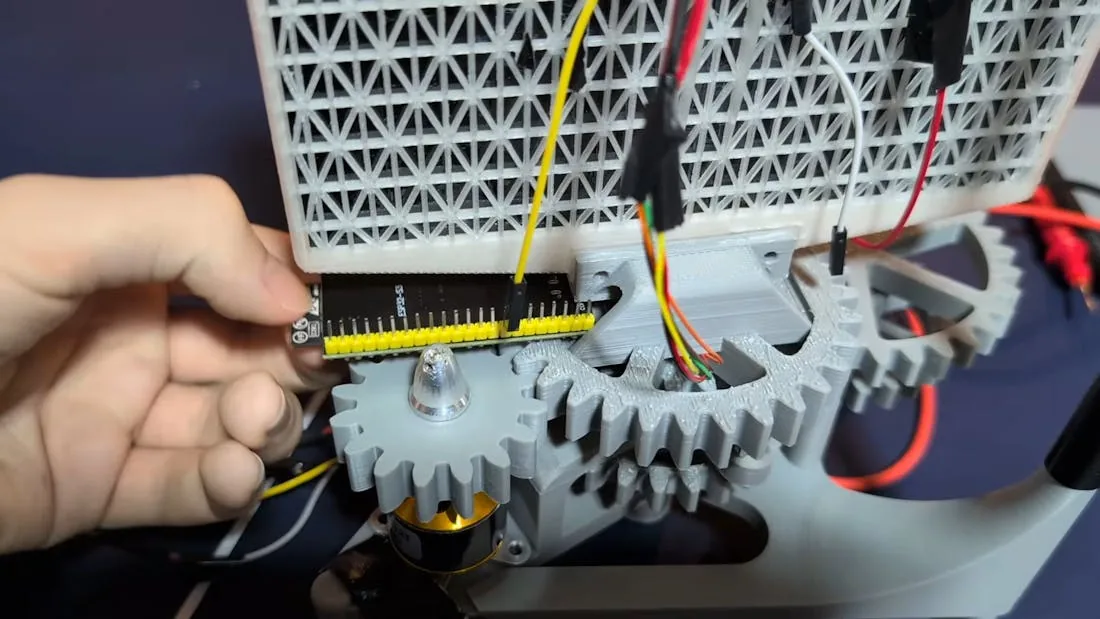 Primer plano del ESP32, el tren de engranajes impreso en 3D y el motor en la base giratoria
