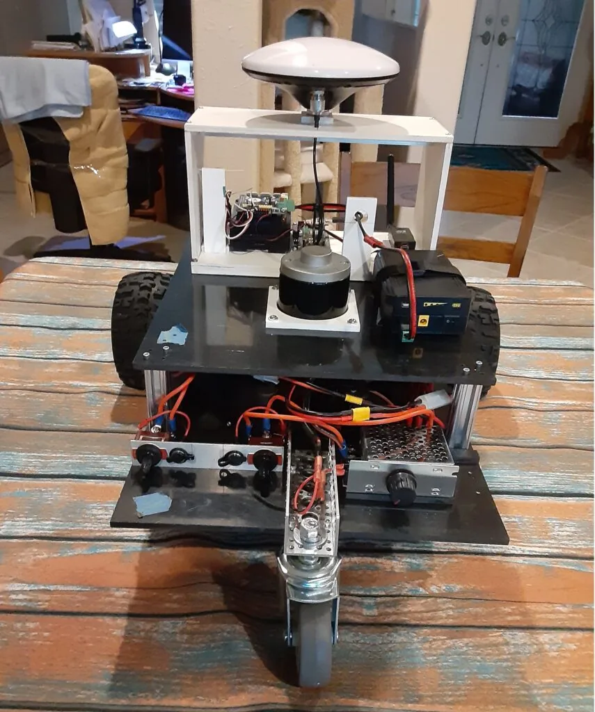 Segunda planta del chasis con el módulo de guiado GPS RTK montado: antena en domo, mini PC y radio de telemetría, separados del ruido de los motores