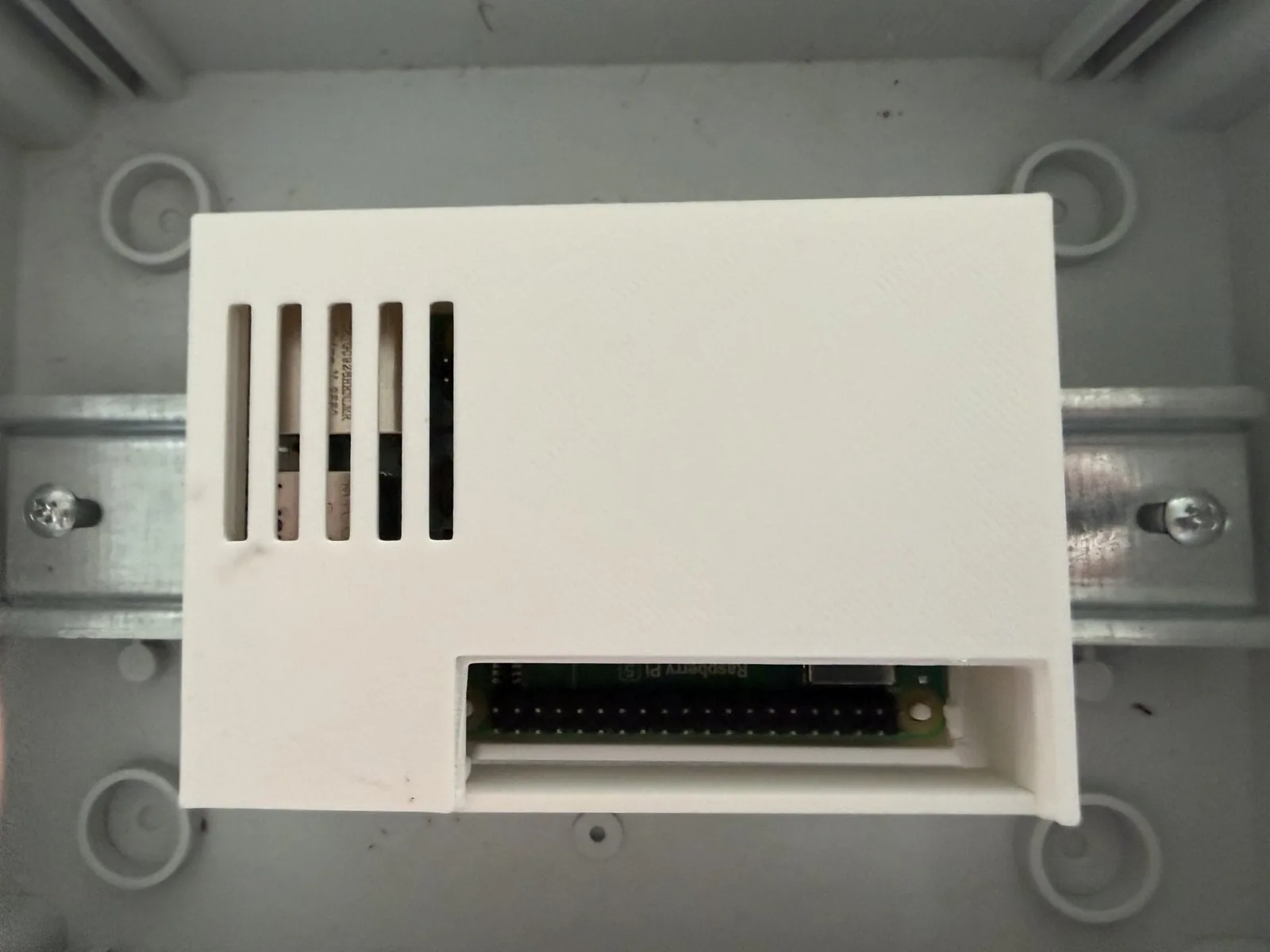 Gabinete cerrado con la tapa puesta, el campo sobre los pines GPIO retirado y las ranuras de ventilación al costado
