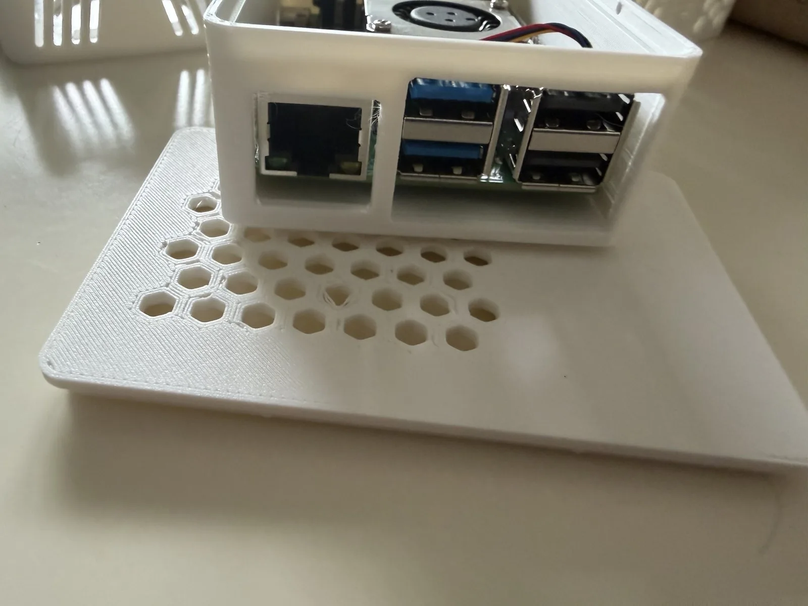 Costado de puertos de la carcasa impresa: una abertura continua para los cuatro USB y, separada por un tabique, la de Ethernet