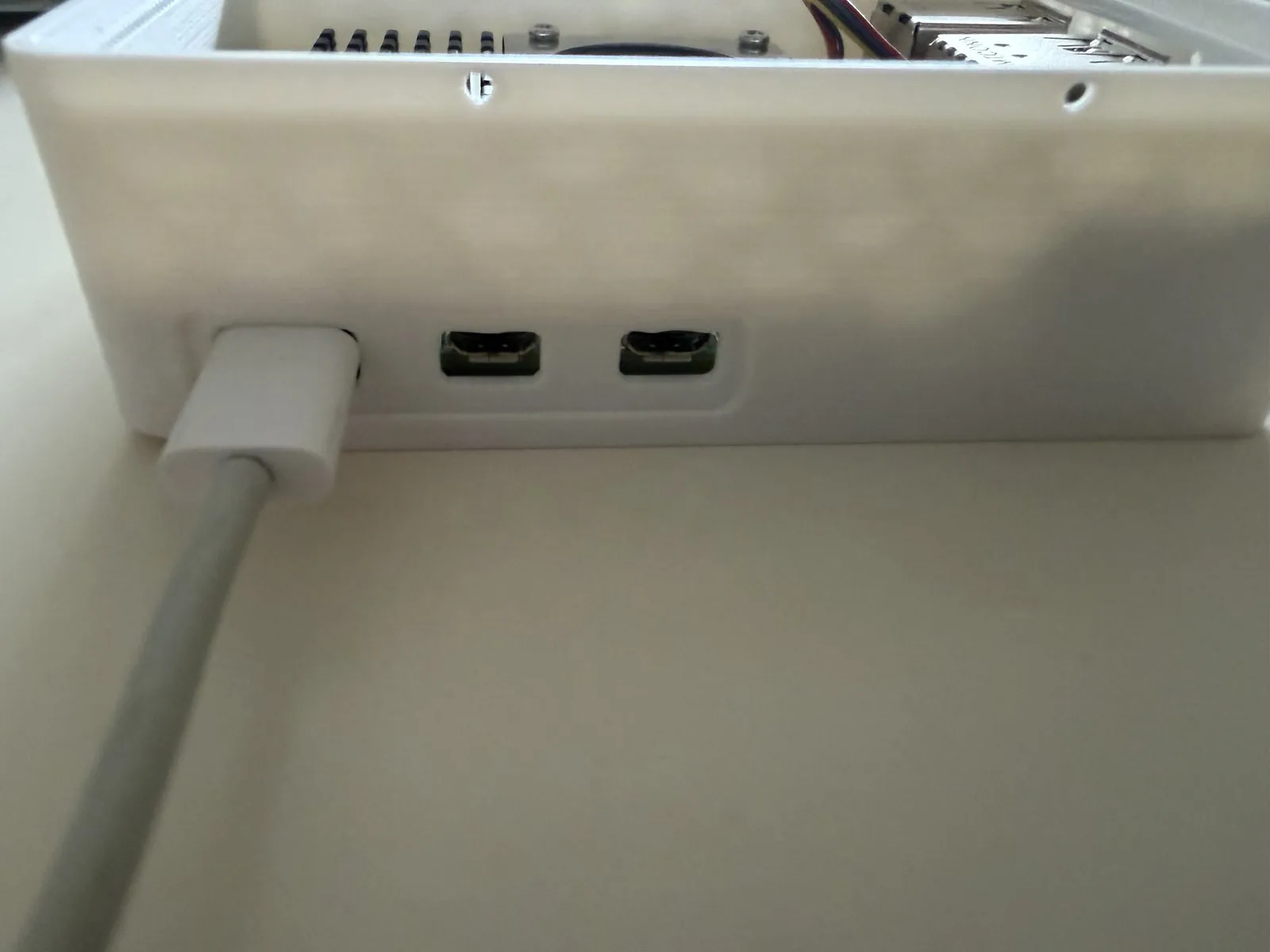 Cable USB-C conectado en la carcasa impresa, con las dos salidas micro HDMI libres al lado