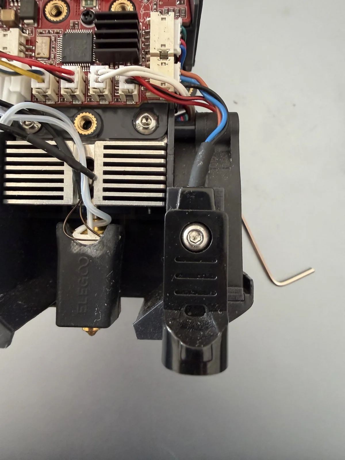 Sonda inductiva de fábrica del Neptune 4 Plus junto al hotend, sujeta con un tornillo Allen