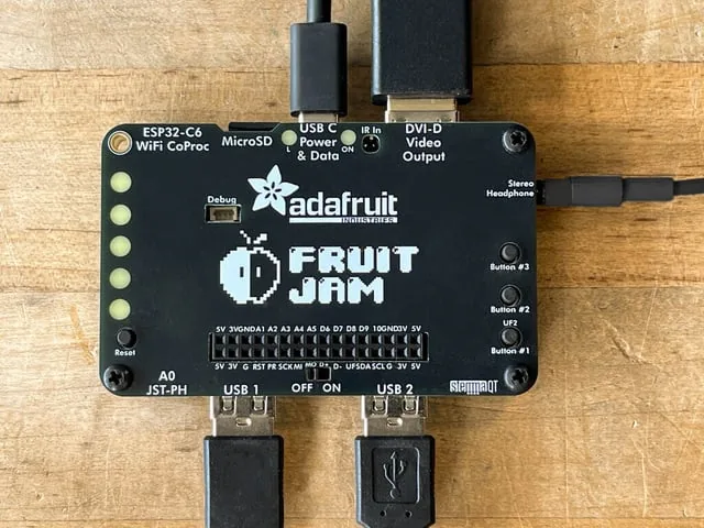 Vista superior de la placa Adafruit Fruit Jam con sus puertos rotulados: microSD, USB C, DVI D y audio