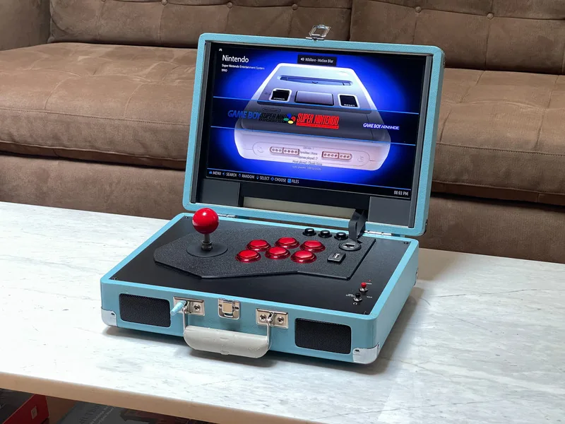 Arcade portátil armado dentro de un maletín de tocadiscos, con joystick y botones en el panel