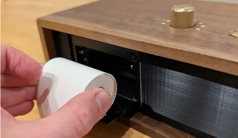 Cambiando el rollo de papel termico de 58mm en la ranura frontal de la consola