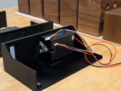 Impresora termica montada sobre el chasis impreso en 3D con su arnes de cables de colores hacia los GPIO de la Pi