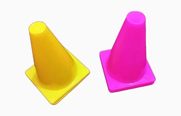 Dos conos de tránsito plásticos, uno amarillo y uno rosado, listos para convertir en balizas iluminadas