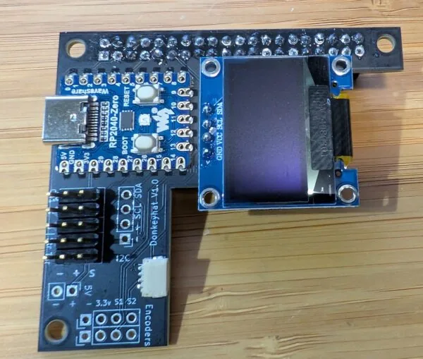 Placa RC Hat vista desde arriba con el RP2040-Zero, la OLED y los conectores rotulados de entradas, servos, encoders e I2C