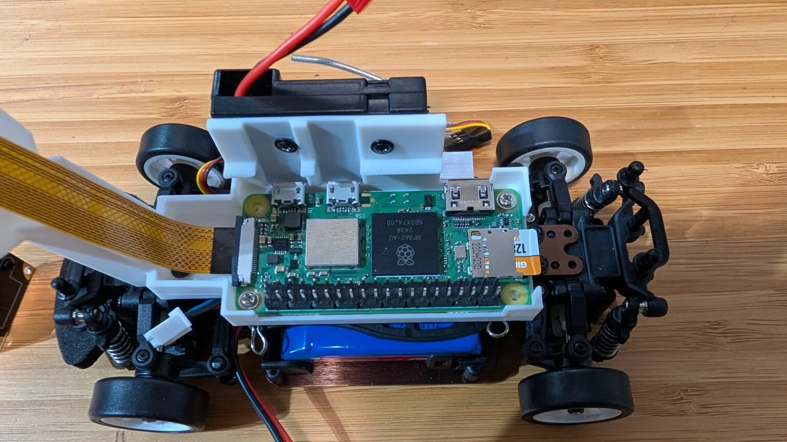 Raspberry Pi Zero 2 W instalada sobre el chasis del auto RC con el chip RP3A0 a la vista