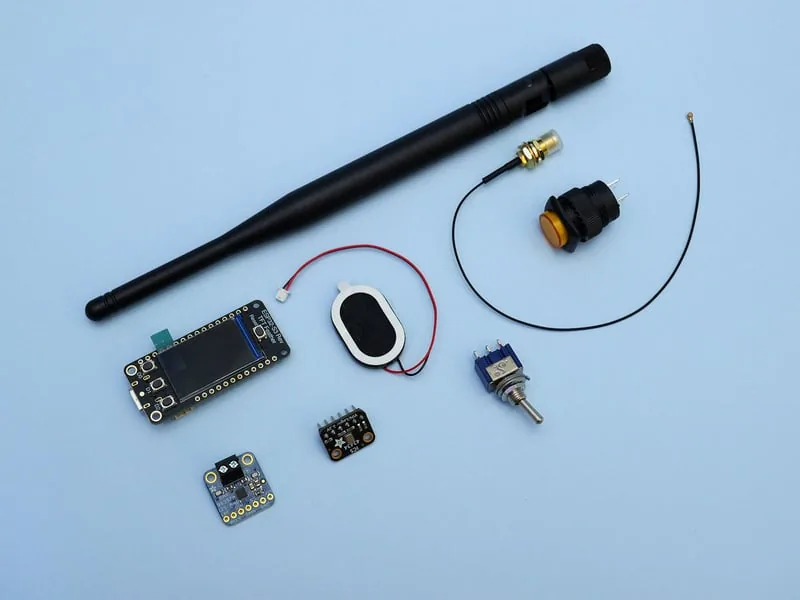 Componentes del walkie talkie: placa ESP32-S3 Reverse TFT, antena 2.4GHz con pigtail, parlante ovalado, micrófono I2S, amplificador I2S, pulsador iluminado y switch