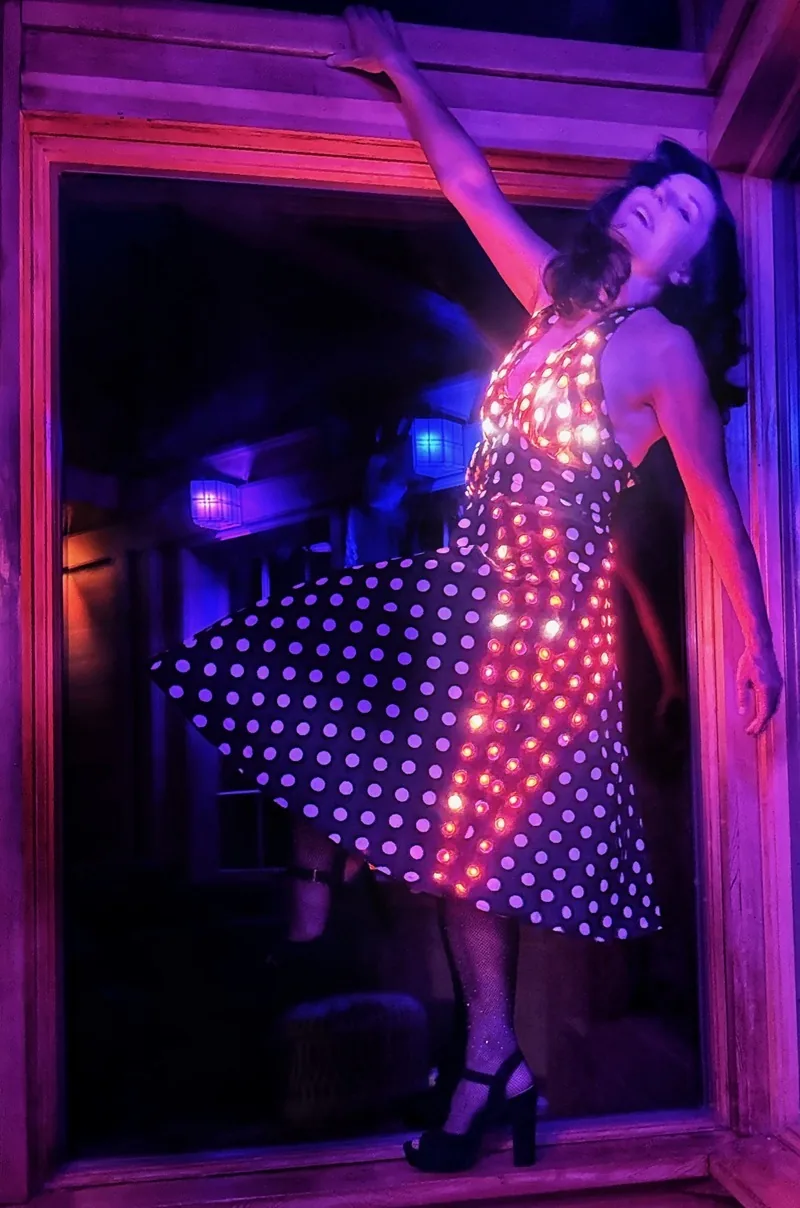 Vestido de lunares con LEDs encendidos frente a una ventana