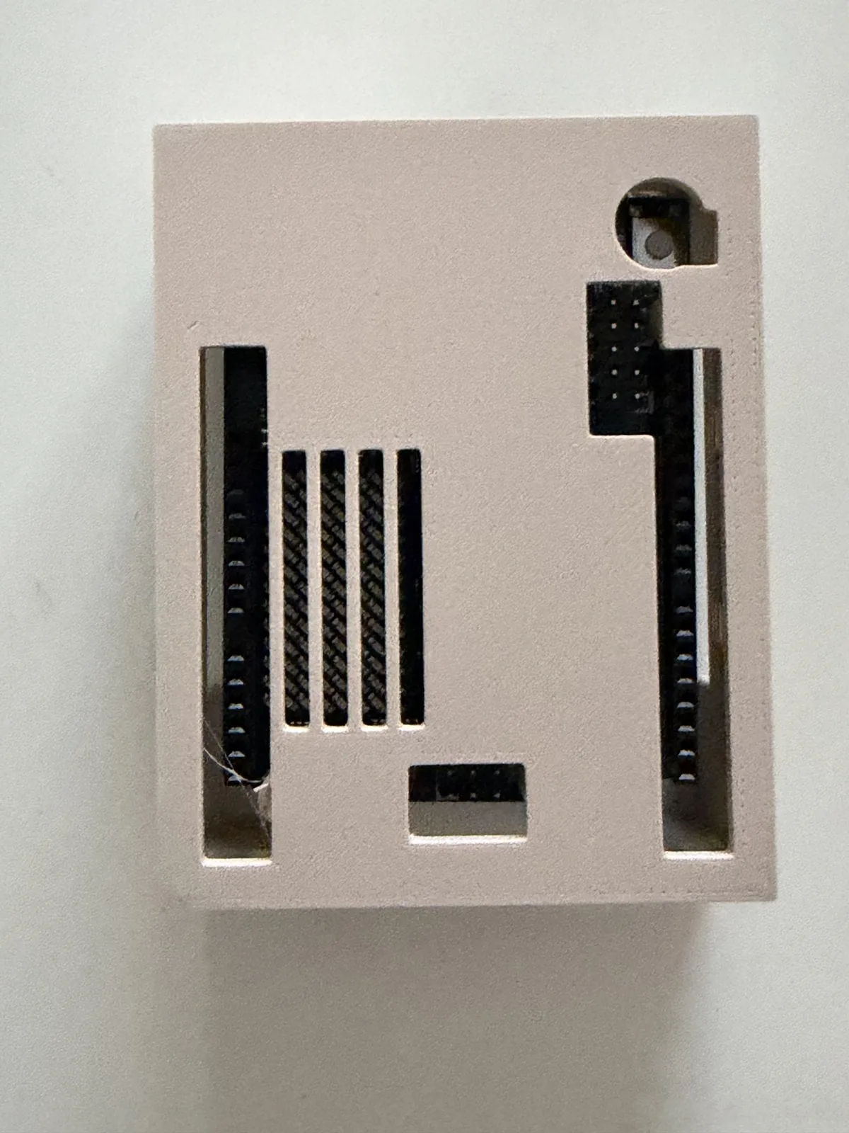 Vista superior de la tapa montada, con la rejilla de la matriz LED, las ranuras de los GPIO y el botón de encendido