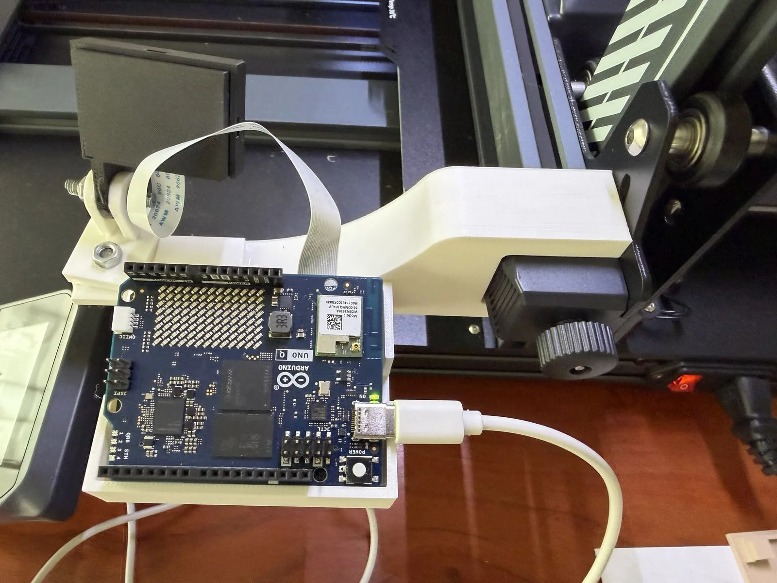 La placa Arduino UNO Q en la bandeja impresa, con el cable de cámara y el USB-C saliendo por las ranuras laterales